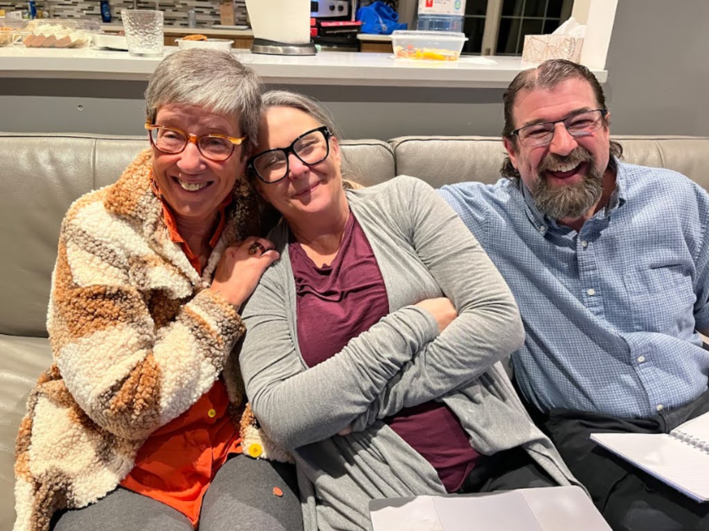 Three people sitting together on a couch