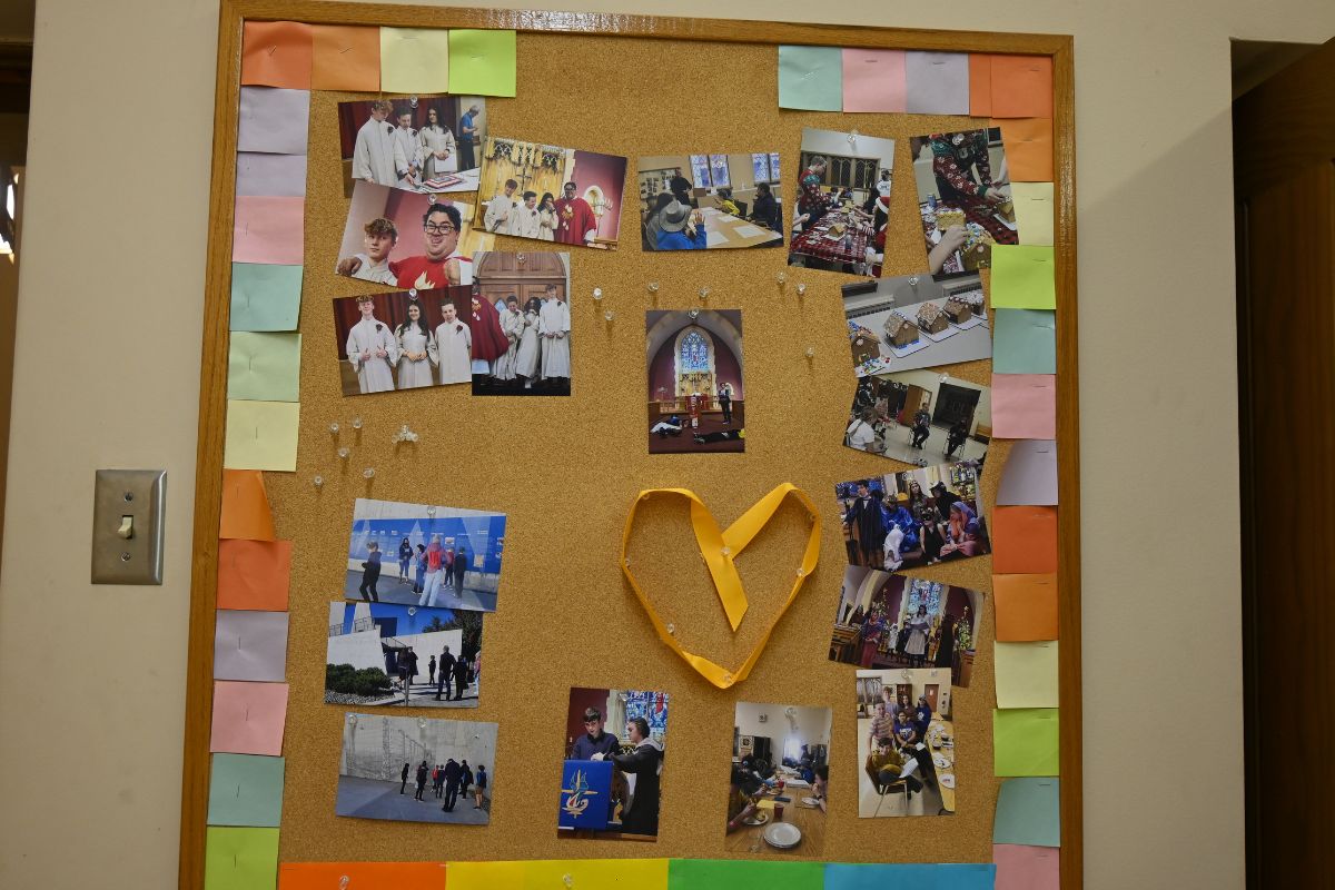A bulletin board with a bunch of colourful sticky notes and photos pinned to it.