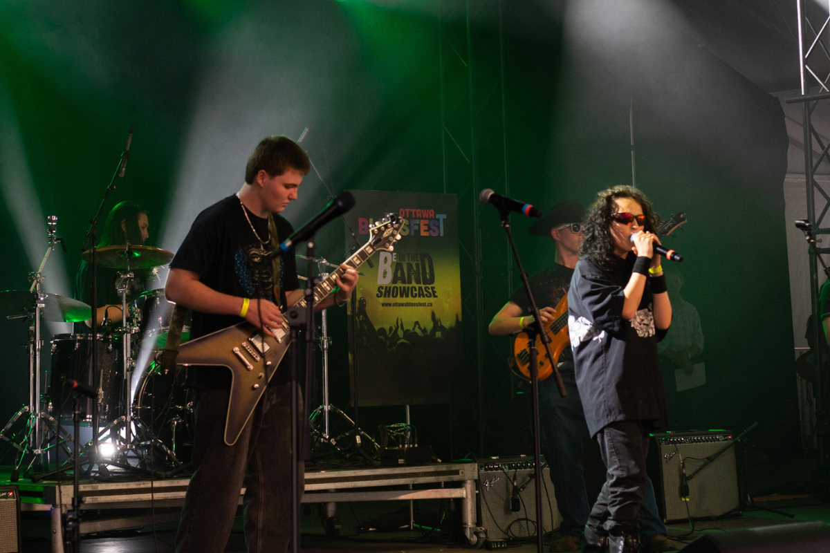 A band of kids perform up on stage.