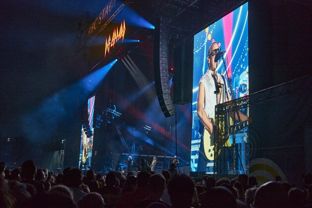 A crowd perspective of a band playing on stage.