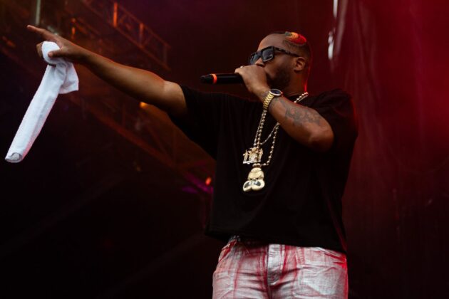 A rapper points somewhere off in the distance on stage.