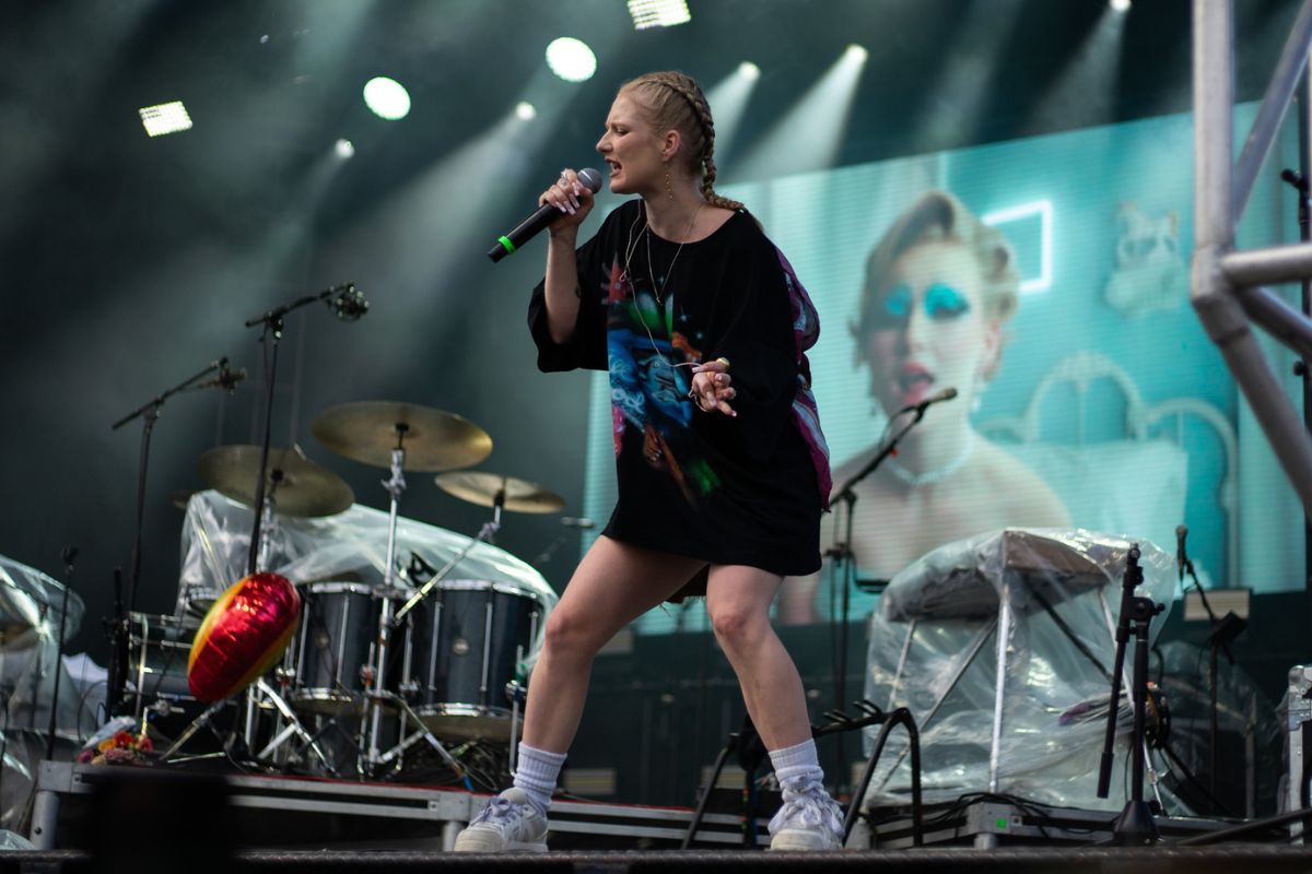 A person sings on a green-glowing stage.