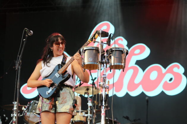 A guitar player plays on a stage.