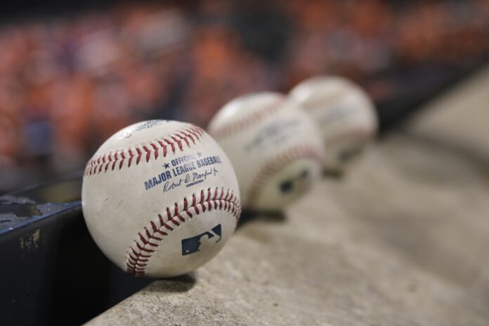 Three baseballs sit on a concrete slab.