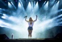 Bluesfest Day 4 review: Shania Twain livens up Bluesfest after chill, post-rain performances A woman with a white and black sparkly outfit performs on a stage with all spotlights turned to her.