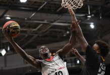 Isaih Moore’s record-setting performance helps BlackJacks defeat Honey Badgers Basketball player in mid air attempting to score a basket.