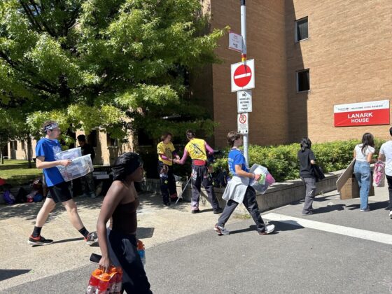 People walking holding boxes.