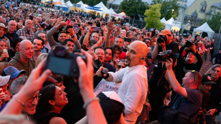 A singer performs in a crowd of people.