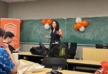 NDP MP Heather McPherson talks affordability, Palestine at uOttawa town hall Woman speaks to crowd in front of chalk board.