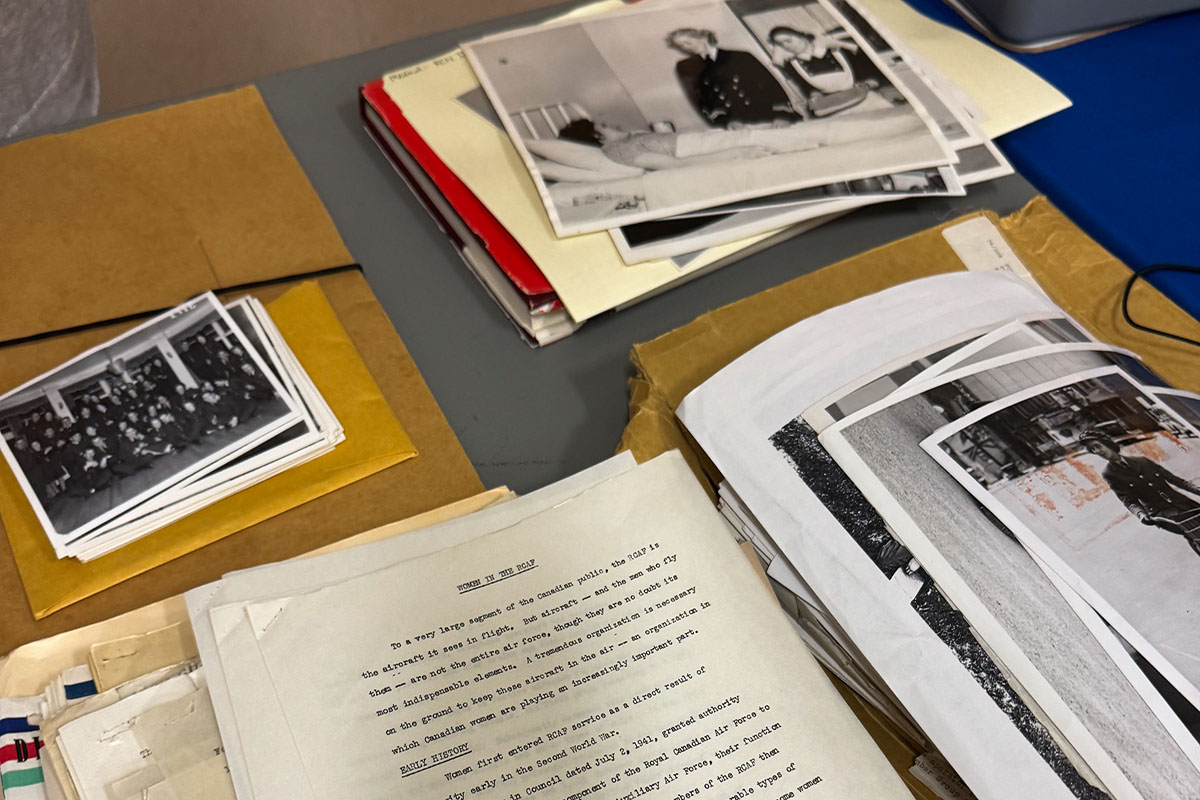 Black and white photos of women in military uniforms and papers with unclear words on a table.