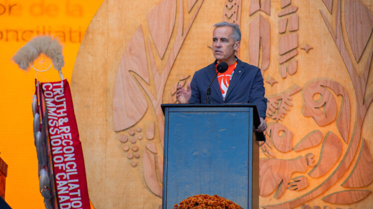Mark Carney stands at a podium