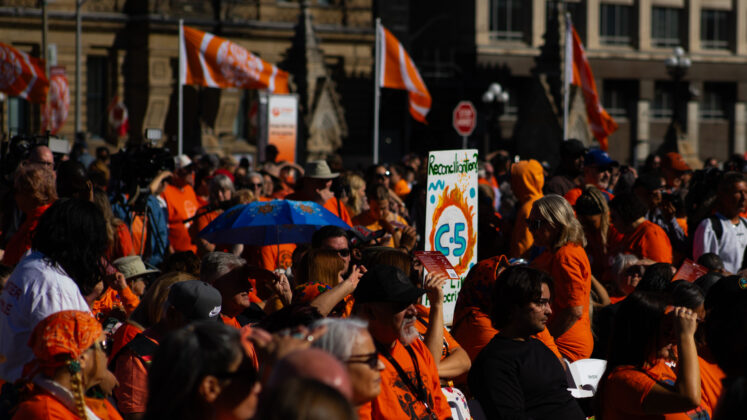 a crowd of people with orange shirts and orange flags