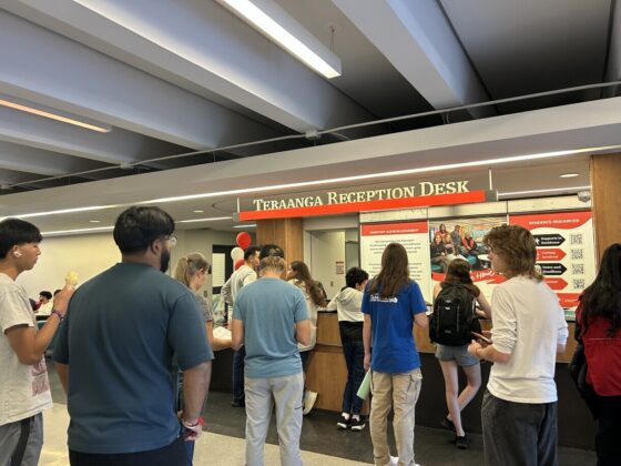 People in line in front of a desk.