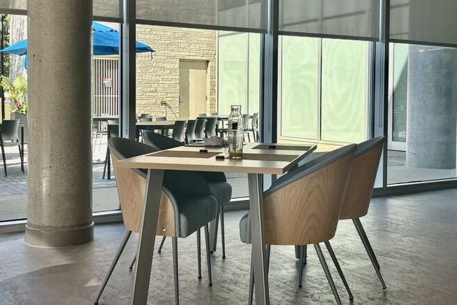 A restaurant table with four chairs sits in the middle of a well-lit room.