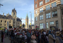 In photos: Ottawa protesters mark two-year anniversary of military siege in Gaza a crowd marches in front of Parliament Buildings