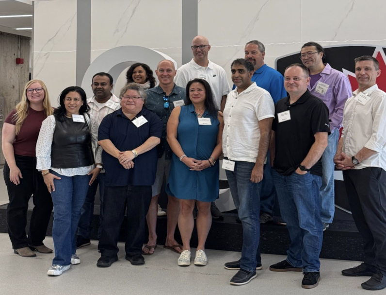 A dozen members from the Engineering Class of 2000 stand in front of the CU sign.