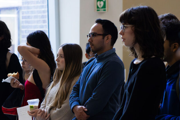 People stand in lines and look towards the stage