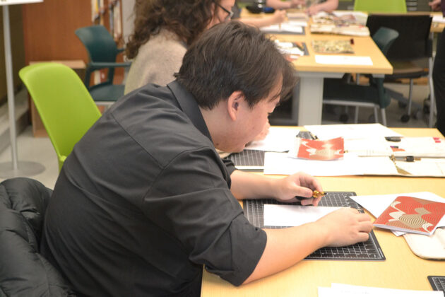 A person sits at a table with a paper in front of them