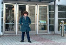 ‘Soon, they’re going to start listening’: Carleton Transit Riders make first appearance at City Hall A person stands in front of silver doors with an O logo for the City of Ottawa on the doors