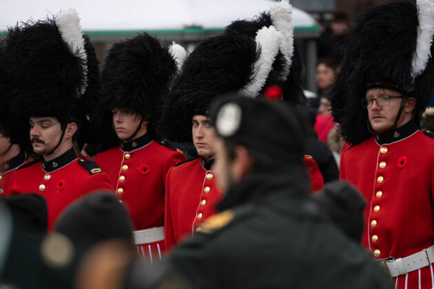 Marching band members stand.