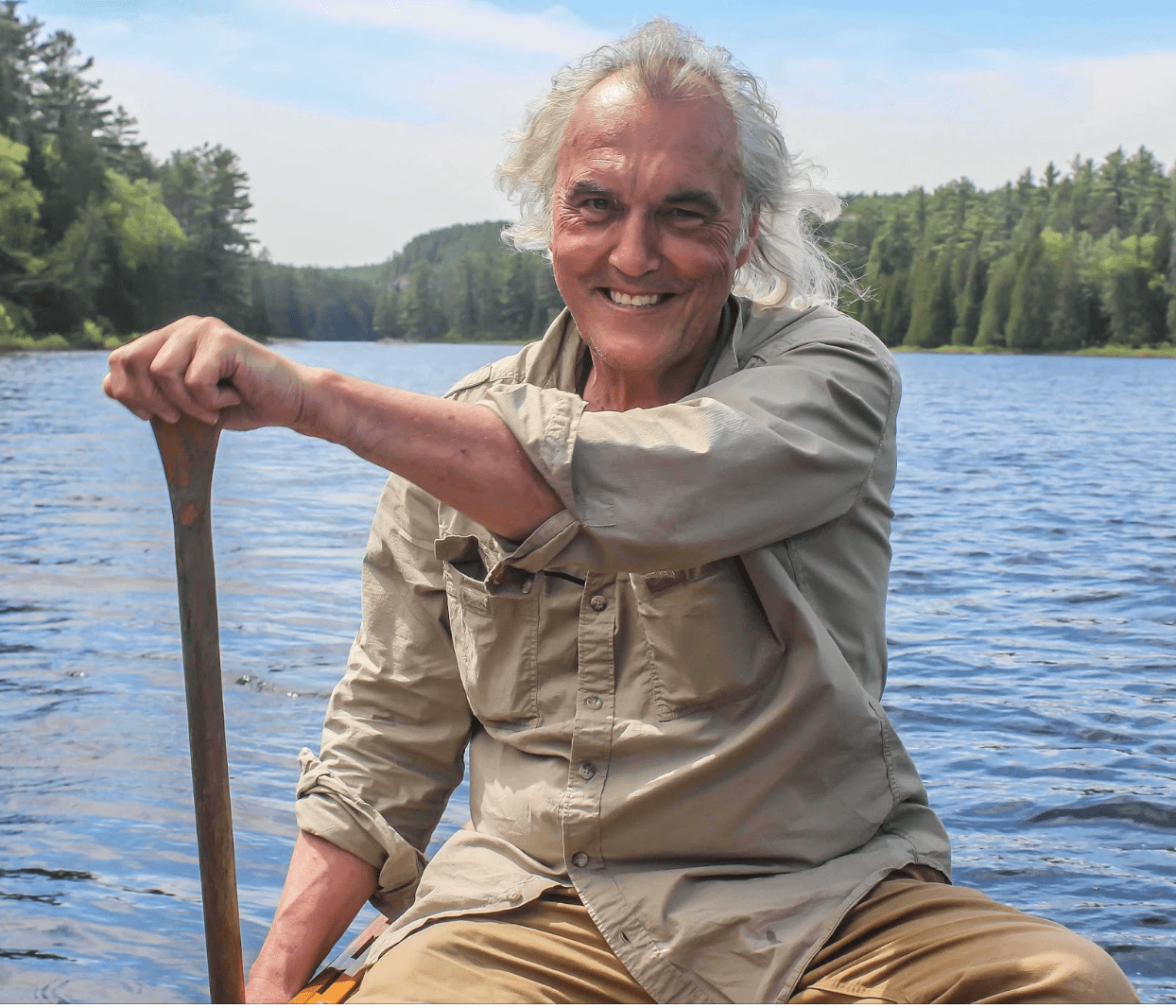 A man canoeing on blue water.