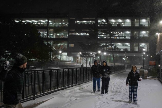 People play in the snow during a snowstorm at Carleton University.