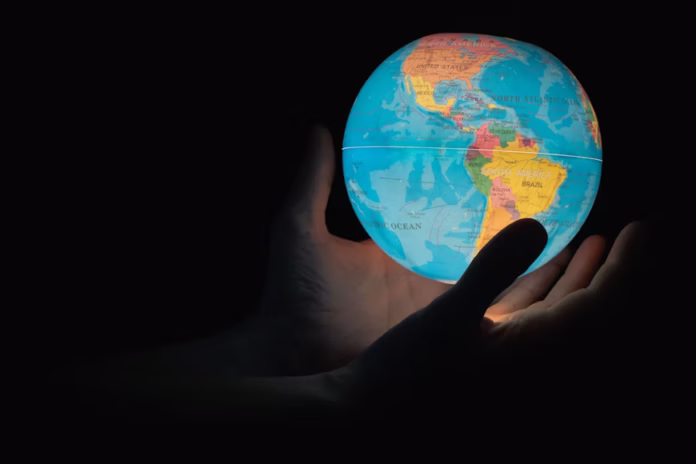 A man holding a world globe in his hands