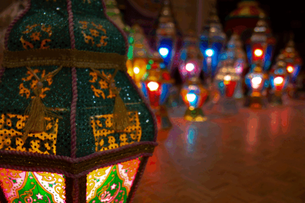 A colourful lantern sits on a floor with several others in the background