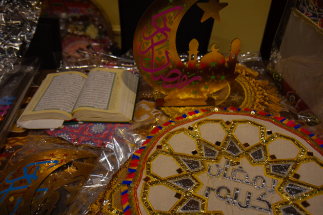 A gold moon decoration and an open book sit on a table.