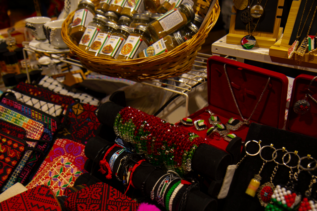 bracelets, and wallets, as well as a basket of jars filled with spices sit on a table