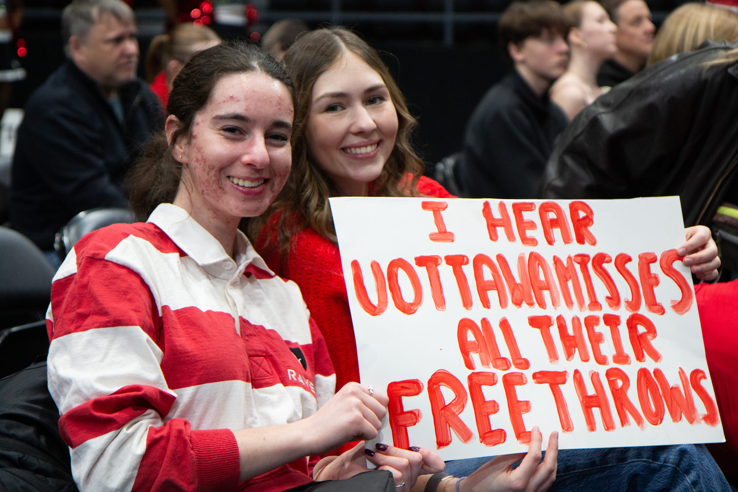 Two fans holding a sign.