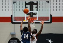 ‘It was electric’: Ravens explode in fourth quarter to knock out Varsity Blues, advance to Wilson Cup Two basketball players in the air with the ball
