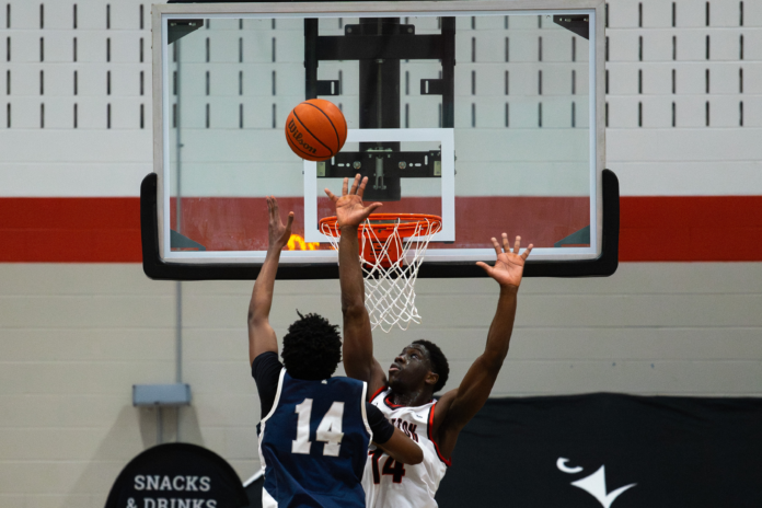Two basketball players in the air with the ball