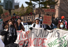 Campus protest calls on Board of Governors to divest from human rights violations A crowd of people holding signs with messages like "Stop funding genocide, divest now," "We CU investing in genocide," "divest from apartheid," and "You're on the wrong side of history"