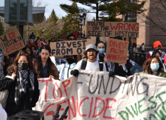 Campus protest calls on Board of Governors to divest from human rights violations A crowd of people holding signs with messages like "Stop funding genocide, divest now," "We CU investing in genocide," "divest from apartheid," and "You're on the wrong side of history"