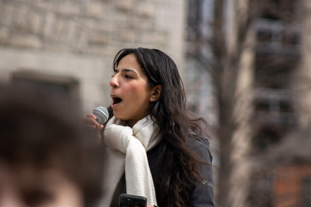A woman holds a microphone up to her mouth.