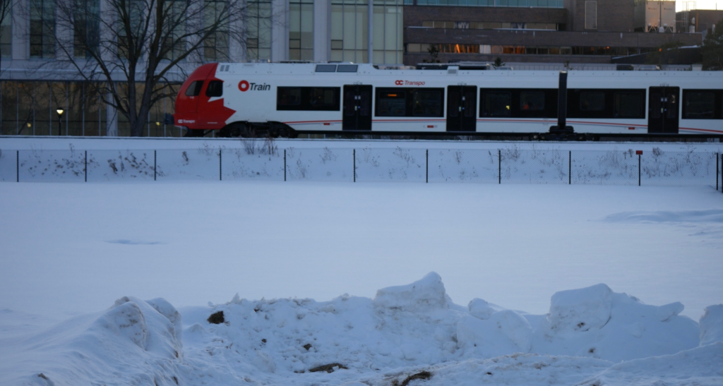 O-train goes past with snow in foreground