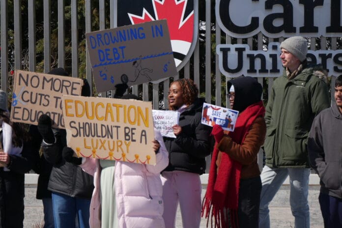 People holding a sign and protesting OSAP changes