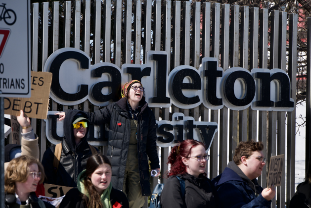 Person yelling in front of Carleton sign