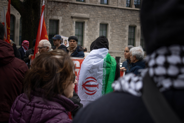 An attendee at the protest wears the flag of Iran on his back