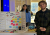 No Room for Students: How a CUSA report is highlighting student rent issues Two people stand at a table with a fold-out cardboard poster with sticky notes and a message that says "Let's talk about rent, your rent"