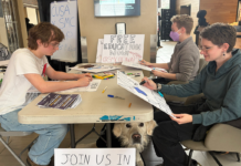 Student advocates draw signs — and awareness — for OSAP cut protest Three people sit at a table that has markers and posters (some homemade, some printed)