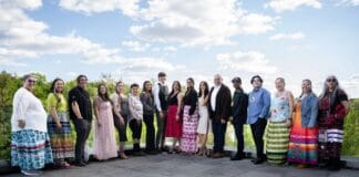 ‘We quickly became a family’: Carleton’s Indigenous journalism certificate wraps up its first year People line up outdoors on a concrete patio at Carleton University. There's a bright blue sky with the people standing and smiling across the frame.
