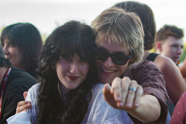 Two people smile at camera in crowd outside