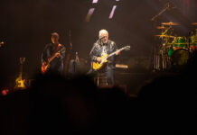 Bluesfest Day 9 review: The Guess Who closes Bluesfest with a powerful Canadian celebration Guy plays guitar on stage with other guitarist behind him.