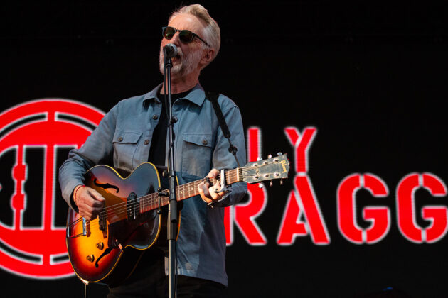 Man with sunglasses plays guitar and sings