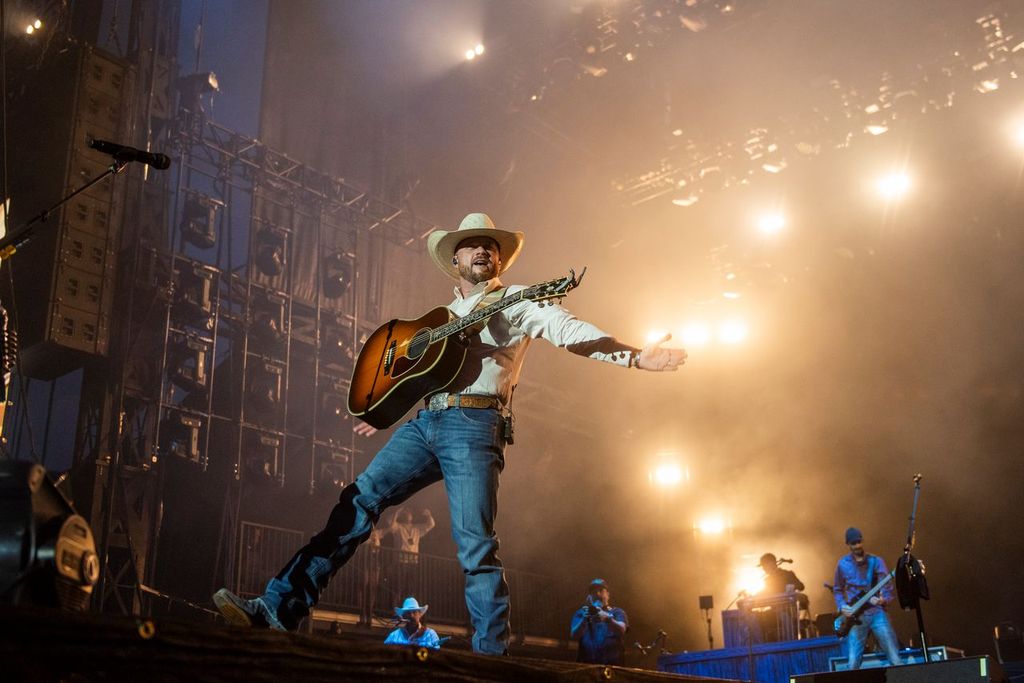 Man strikes a pose with cowboy hat and guitar