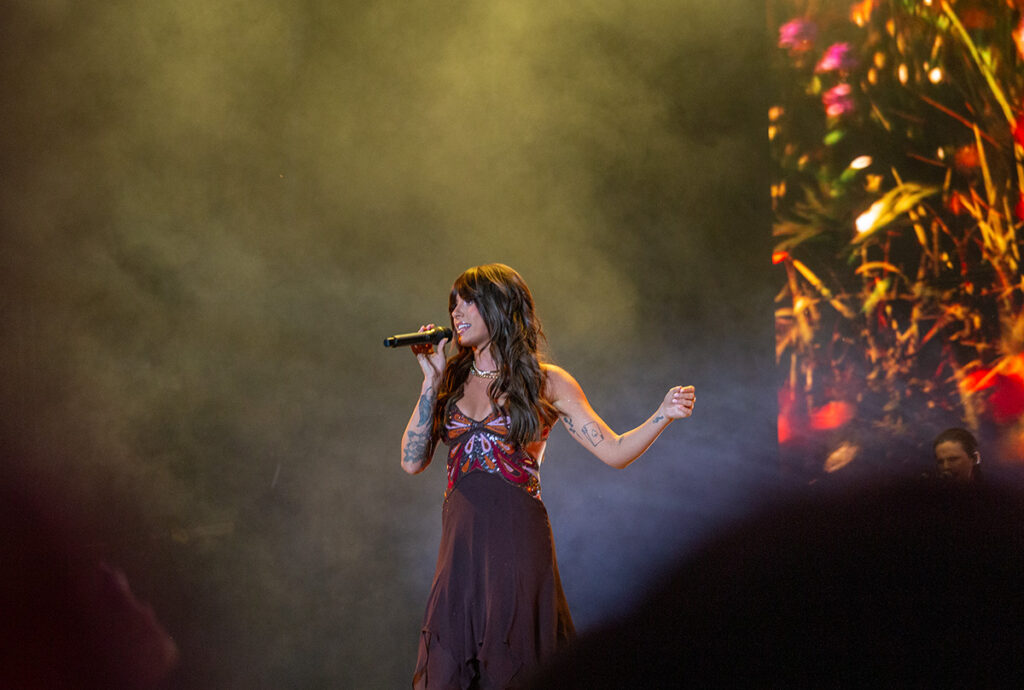 Woman sings with arm out