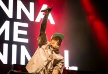 Bluesfest Day 2 review: Limp Bizkit brings the house down with metal nostalgia and a hometown surprise Man raises arm with microphone on stage with song lyrics behind him