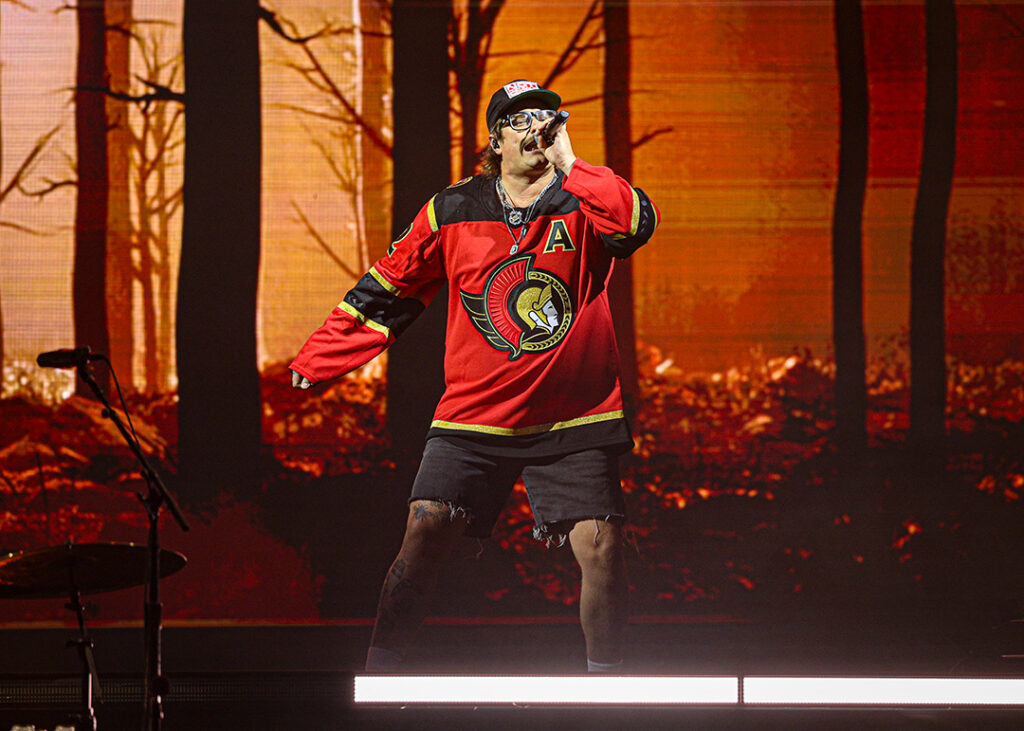Man sings on stage wearing Sens jersey